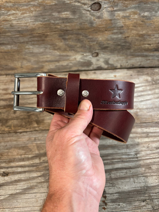  dark brown leather belt with a silver buckle and silver rivets, featuring an embossed star logo and the brand name